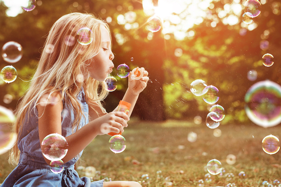 Portrait of a cheerful girl blowing soap bubbles